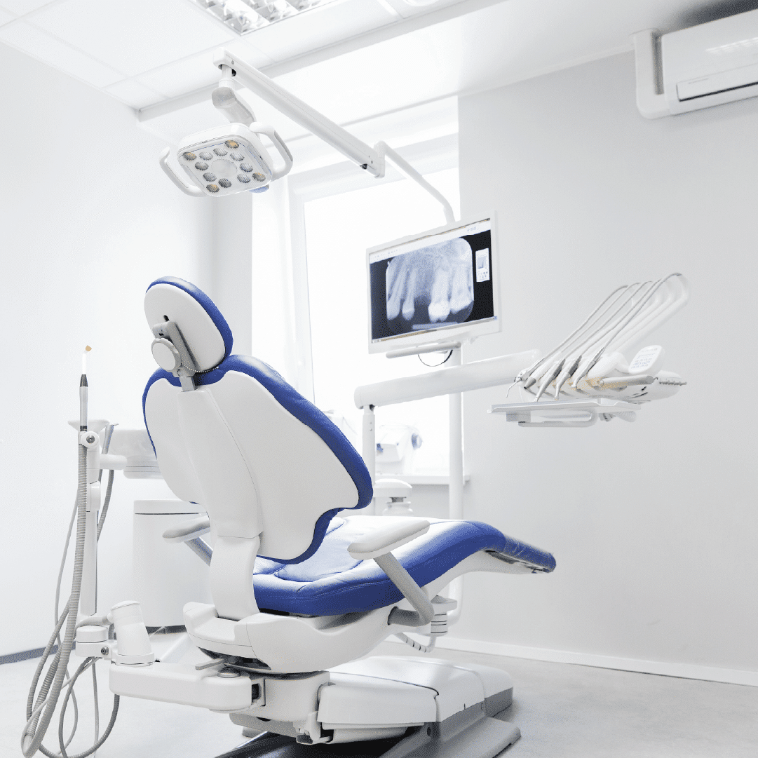 Dental examination chair in modern clinic with overhead light and monitor displaying X-ray, emphasizing advanced dental care at Dr. Chelsea Mason Dental in Bay City, MI.
