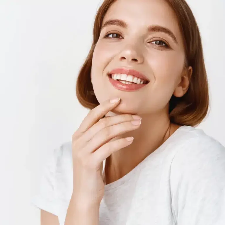 Smiling woman with healthy teeth and hand on chin, representing confidence in dental care and emergency dental services.